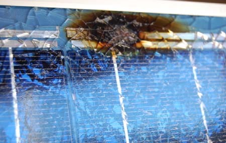 burn mark and shattered glass on front of panel